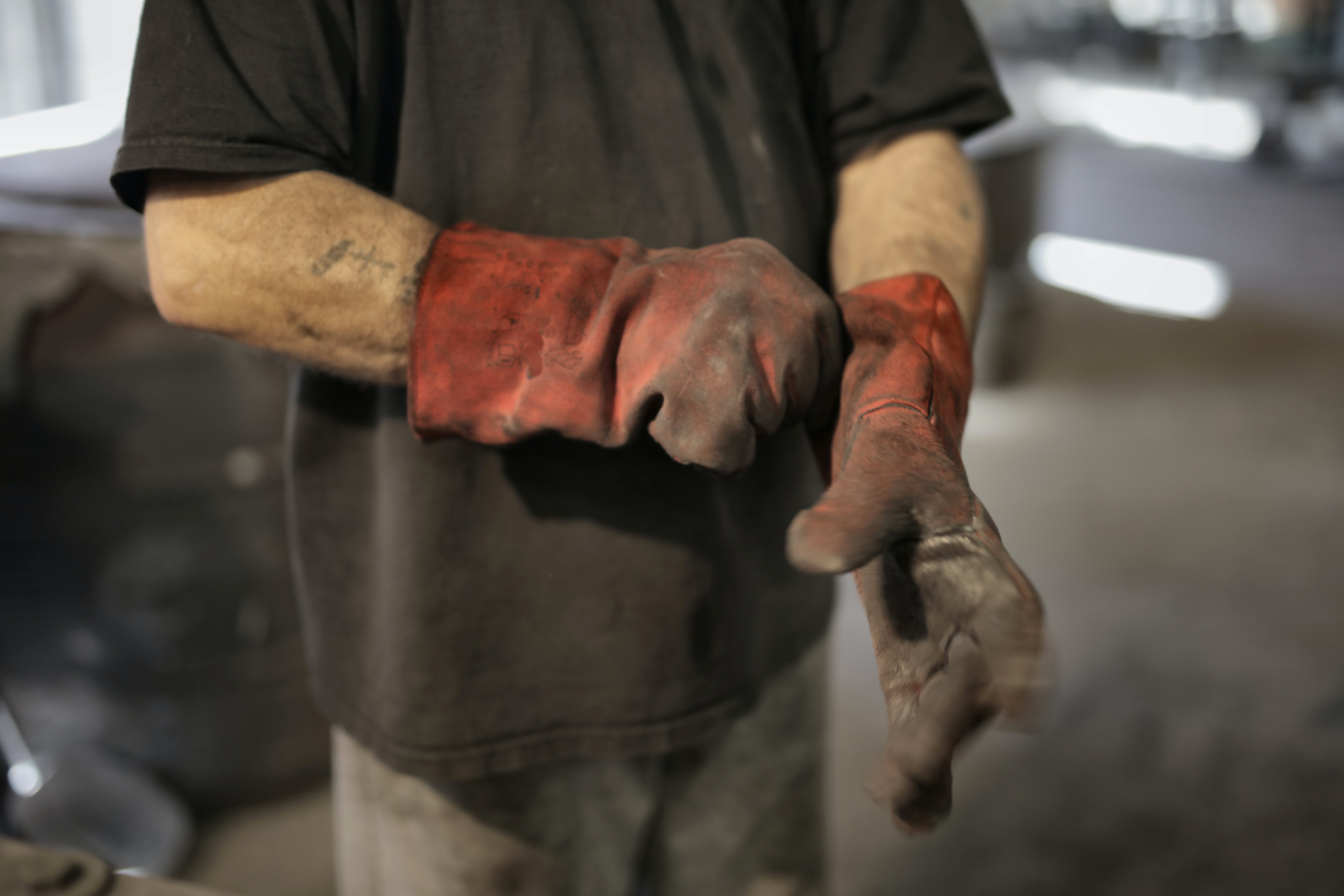 Man putting on dirty heavy duty work gloves
