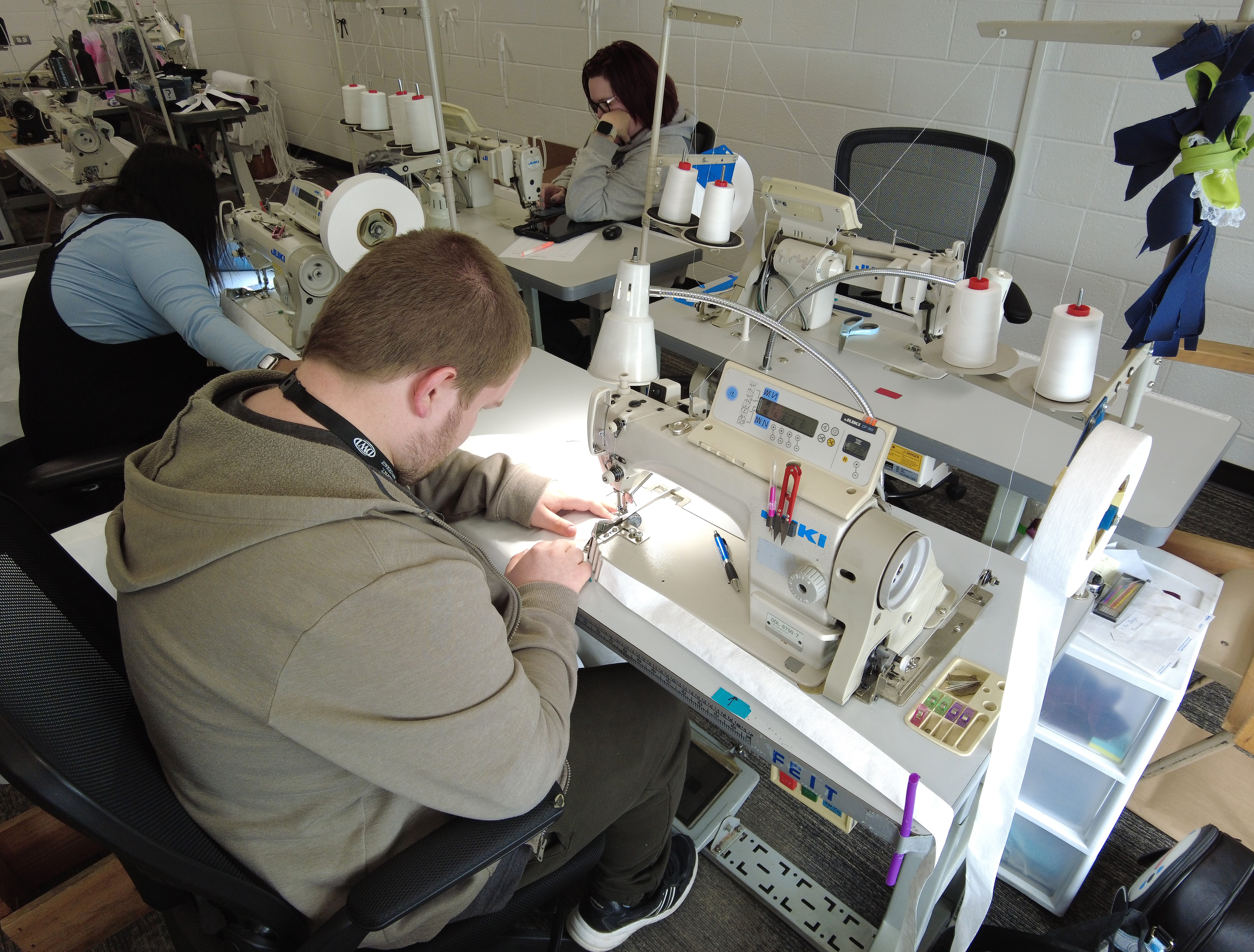 man sitting in front of sewing machine