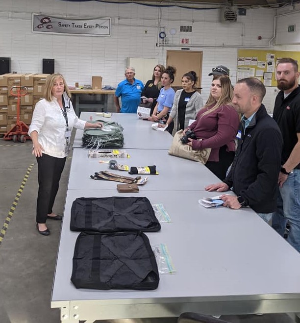 Lori presenting sewing items to a number of guests