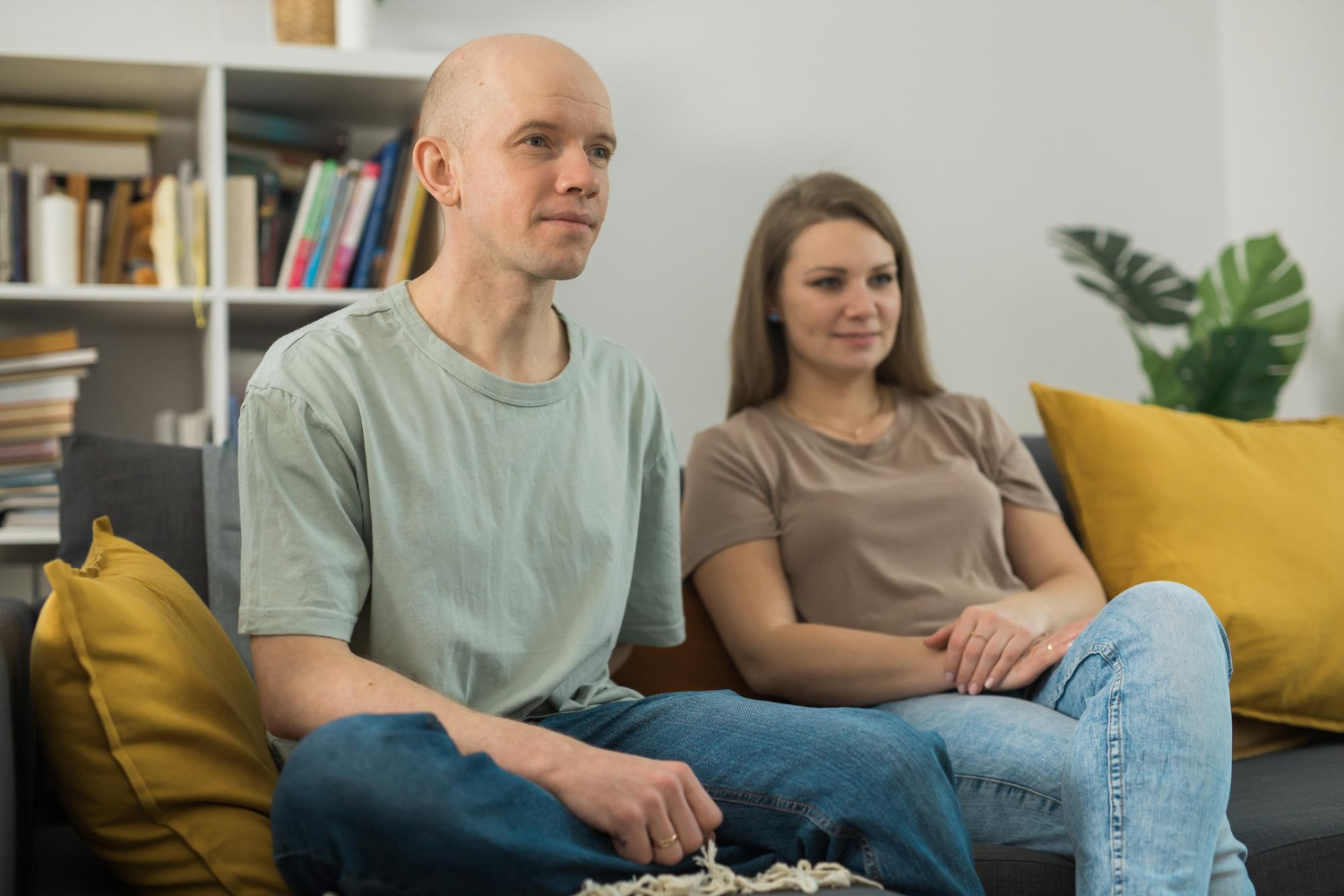 Man and woman sitting on couch looking forward
